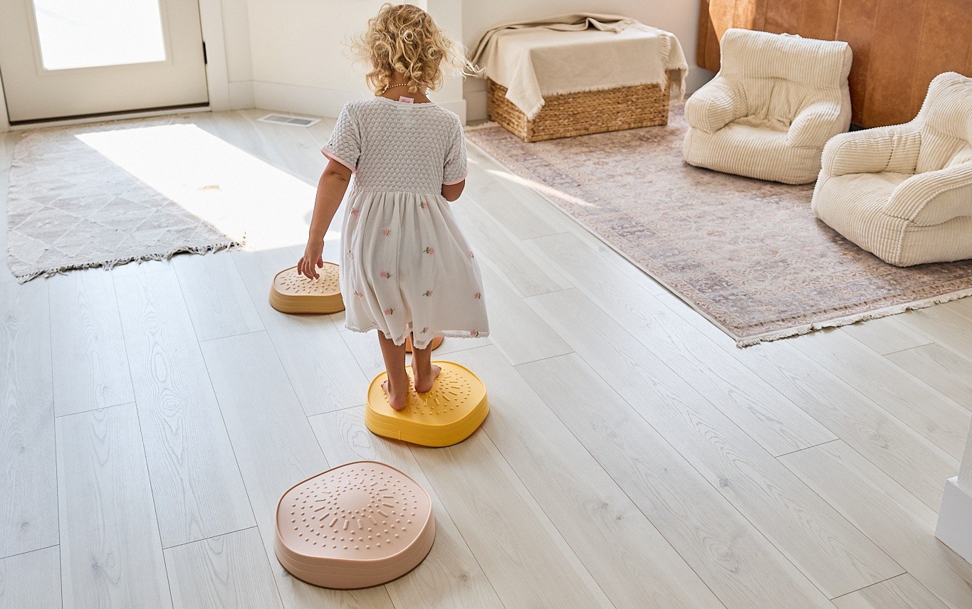 Emery balancing across the Tiny Land Stepping Stones in Sunset Hues in our living room